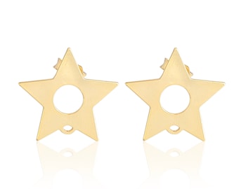 May include: A pair of gold-toned star-shaped stud earrings. Each earring features a flat, five-pointed star design with a circular cutout in the center and a small loop at the bottom point for attaching additional components or charms.