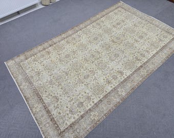 Könnte beinhalten: Rechteckiger beigefarbener Teppich mit aufwendigem Blumenmuster. Der Teppich hat einen detaillierten Rand in Braun- und Beigetönen. Das zentrale Design zeigt ein sich wiederholendes Muster floraler Motive, das einen klassischen und eleganten Look erzeugt.