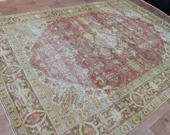 May include: A vintage rug with a faded pink and cream color scheme. The rug has a central medallion with a geometric pattern and a border with a floral design.