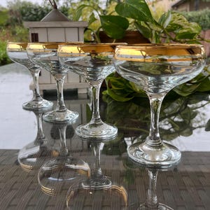 Vier vintage champagnecoupes. Champagneglazen met gouden rand, champagnekommen. Elegante drinkwaren. Mooi glaswerk. Cadeau-idee.