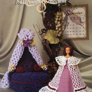 May include: A crochet doll dress and a crocheted doll bed with a canopy. The doll bed is purple and the doll dress is pink with white lace. The image includes the text "Annie Potter Presents 2000 Millennium Collection" and a calendar for September 2000.
