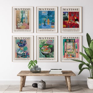 May include: Six framed art prints of paintings by Henri Matisse. The prints feature a variety of colors and styles, including a blue and green landscape, a red and yellow still life, and a portrait of a woman in a blue hat. Each print includes the title of the painting, the date it was created, and the name of the museum where it is currently housed.