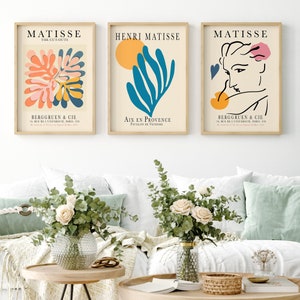 May include: Three framed art prints featuring abstract designs by Henri Matisse. The prints are in a minimalist style with a white background and colorful shapes. The text on the prints reads "Matisse", "The Cut-Outs", "Henri Matisse", "Aix en Provence", "Pavillon de Vendome", "Bergguen & Cie", "24 Rue de l'Universite Paris-VII", and "10, Rue de l'Universite Paris-VII".