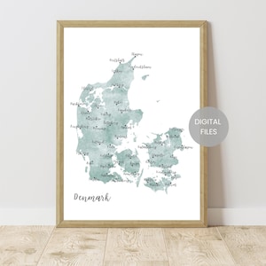 May include: A framed print featuring a watercolor map of Denmark in shades of teal. The map highlights various cities with handwritten-style labels. The word "Denmark" is written in a script font at the bottom. A circular sticker on the right says "DIGITAL FILES".
