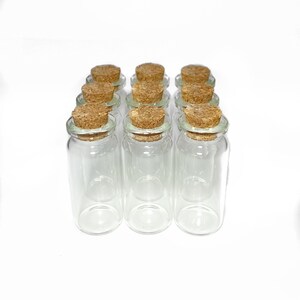 Peut inclure: Douze bouteilles en verre transparent avec des bouchons en li&egrave;ge. Les bouteilles sont dispos&eacute;es en forme rectangulaire.