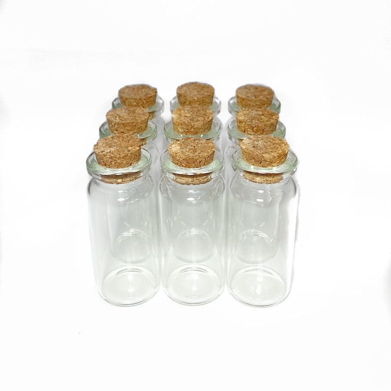 Peut inclure: Douze bouteilles en verre transparent avec des bouchons en li&egrave;ge. Les bouteilles sont dispos&eacute;es en forme rectangulaire.
