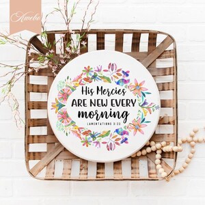 May include: A round wooden sign with a watercolor floral wreath and the text "His Mercies Are New Every Morning" with the scripture reference "Lamentations 3:23".