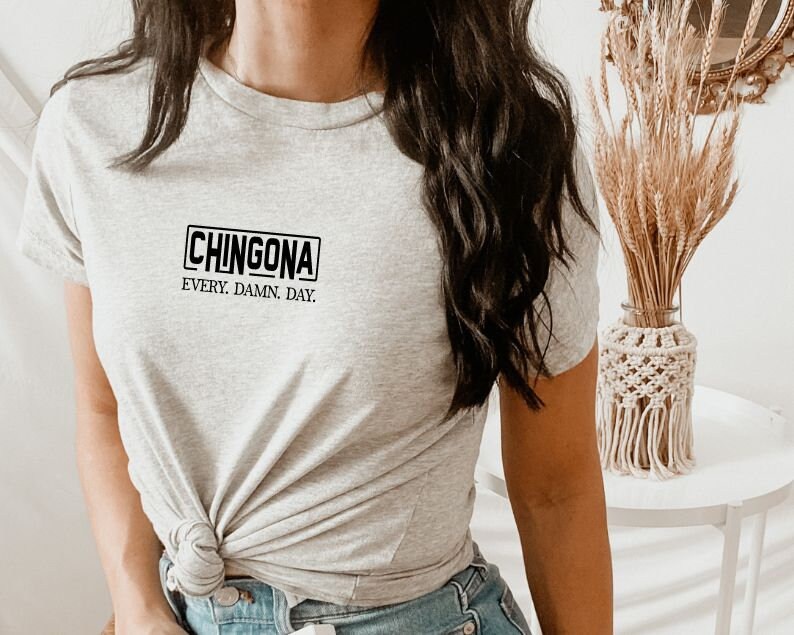 May include: A gray t-shirt with a black rectangle that says "CHINGONA" and the text "EVERY. DAMN. DAY."