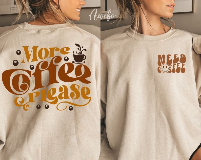 Może przedstawiać: Dwie beżowe bluzy z grafiką związaną z kawą. Jedna bluza ma napis "More Coffee Please" z grafiką kubka z kawą. Druga bluza ma napis "Need Coffee" z grafiką uśmiechniętej twarzy.