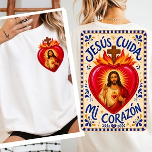 May include: A white t-shirt featuring a small graphic on the front left chest and a large graphic on the back. Both graphics depict the Sacred Heart of Jesus with flames, a cross, and the Spanish text JESÚS CUIDA MI CORAZÓN in blue lettering.