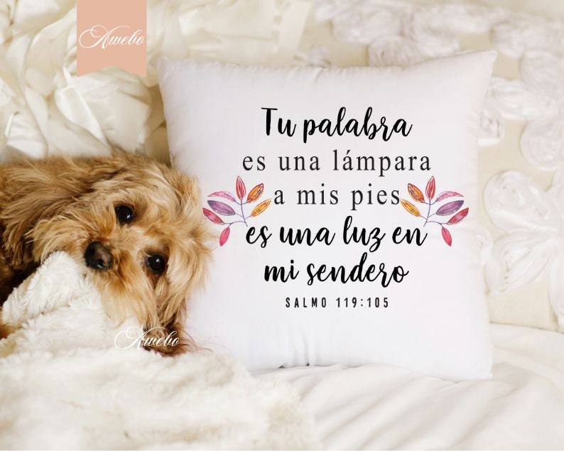 Puede incluir: Coj&iacute;n blanco con una cita en espa&ntilde;ol que dice "Tu palabra es una lampara a mis pies es una luz en mi sendero Salmo 119:105". La cita est&aacute; rodeada de hojas de acuarela en tonos de rosa, naranja y amarillo.