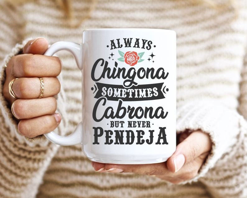 Puede incluir: Taza de cer&aacute;mica blanca con texto negro que dice "Always Chingona Sometimes Cabrona But Never Pendeja". Una rosa roja con hojas verdes est&aacute; por encima de la palabra "Chingona".