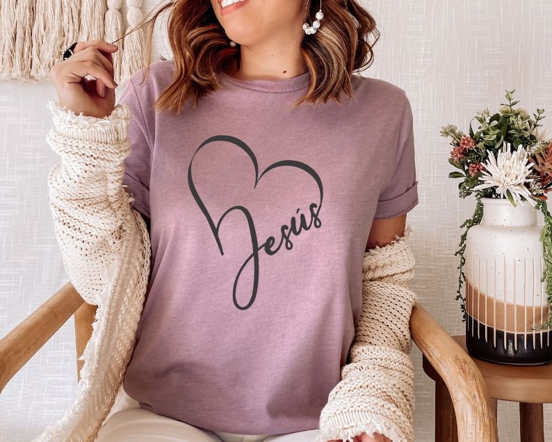 May include: A mauve t-shirt with a black heart design and the word "Jesus" inside the heart.