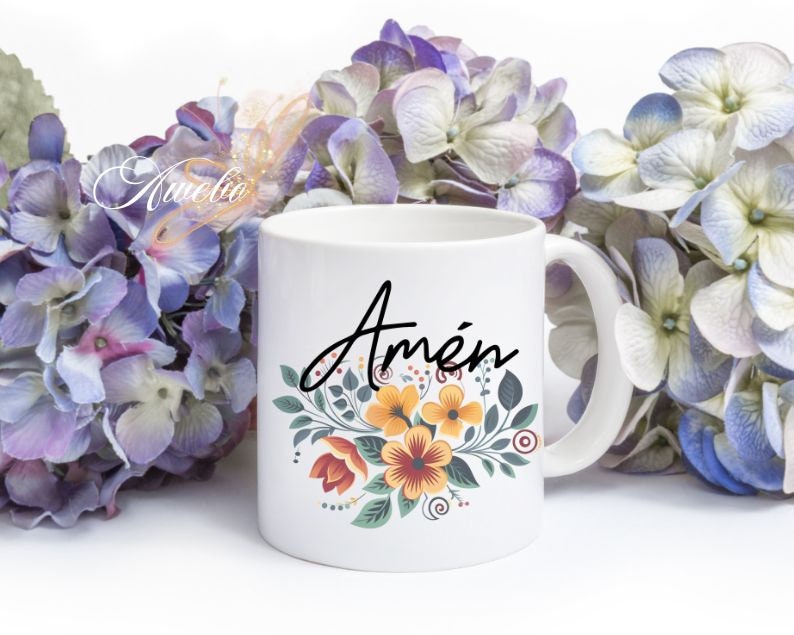 Puede incluir: Taza de cer&aacute;mica blanca con un dise&ntilde;o floral en tonos de amarillo, naranja y rojo. La palabra "Am&eacute;n" est&aacute; escrita en letras cursivas negras en la taza.