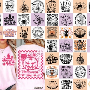以下が含まれることがあります： ハロウィーンをテーマにしたグラフィックが施されたピンク色のTシャツ。1枚のシャツには、クモと魔女の帽子が付いた「Spooky Vibes」と書かれています。もう1枚のシャツには、「Halloween Vibes」という言葉が入ったカボチャのグラフィックがあります。