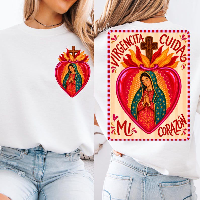 May include: A white sweatshirt featuring a graphic of the Virgin Mary inside a red heart with flames and a cross. The back design includes the text VIRGENCITA CUIDA MI CORAZON in red lettering, while the front shows a smaller version of the same heart.