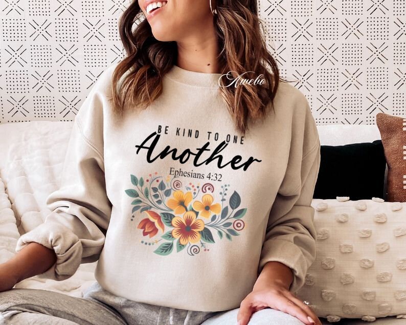 May include: Beige sweatshirt with a floral design and the text "Be Kind To One Another Ephesians 4:32".