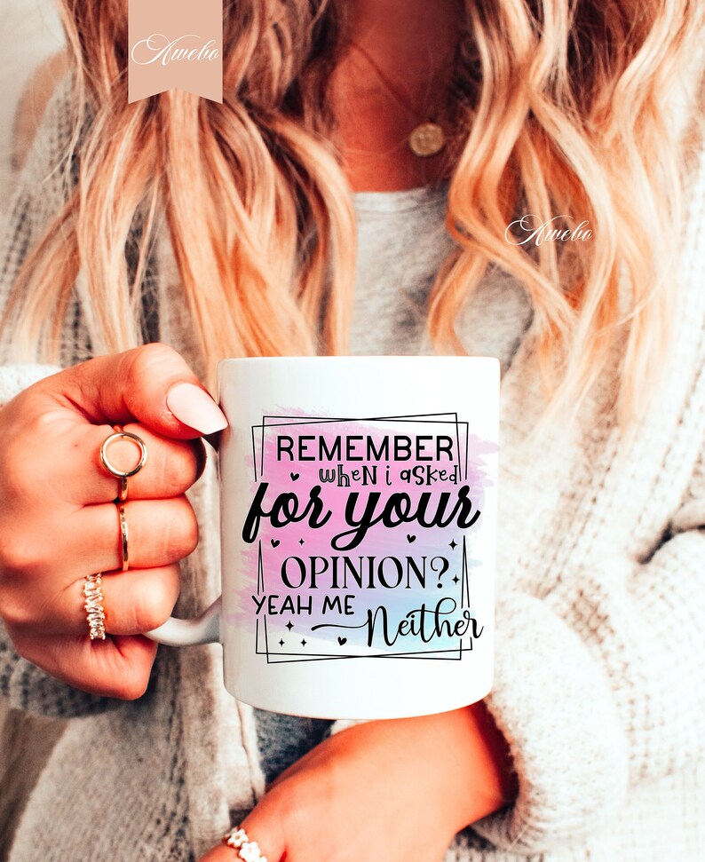 Pu&ograve; includere: Una tazza in ceramica bianca con uno sfondo acquerellato rosa e blu. La tazza presenta un testo nero che recita "Remember when I asked for your opinion? Yeah me Neither".