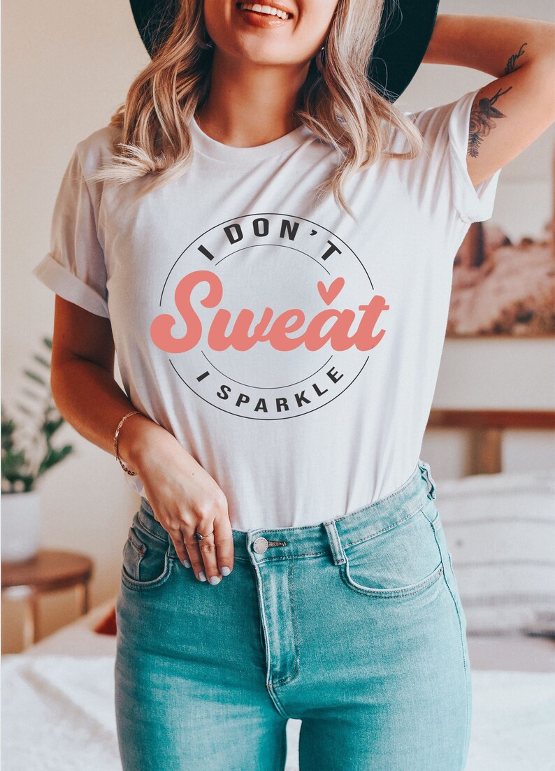 Pode incluir: Camiseta branca com um gr&aacute;fico circular preto que diz "I Don't Sweat I Sparkle" em uma fonte retr&ocirc; rosa.