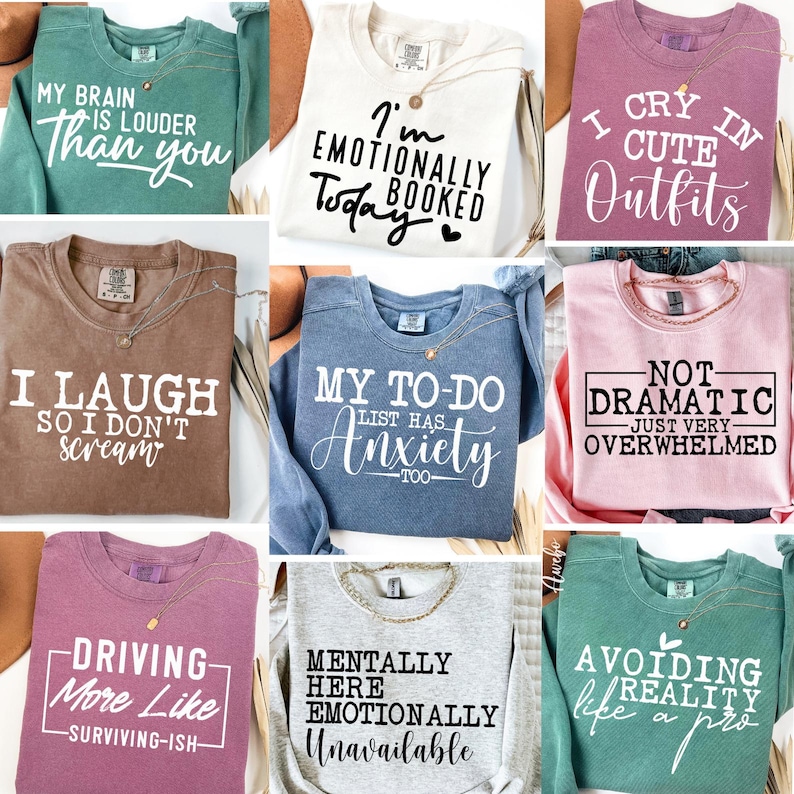 Puede incluir: Nueve sudaderas diferentes con varios refranes humor&iacute;sticos impresos en ellas. Las sudaderas son de diferentes colores, incluyendo azul verdoso, blanco, rosa, marr&oacute;n, azul, rosa claro, gris y verde.