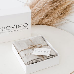 May include: A white box with the text "PROVIMO HOME" on it. The box is open and contains a folded linen towel with a brown twine bow and a small white tag that says "PROVIMO HOME".