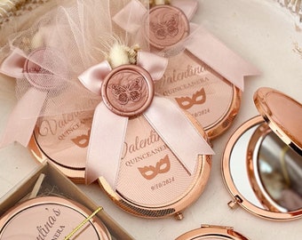 May include: A tray of rose gold compact mirrors with a butterfly design and the text "Valentina's Quinceañera" and the date "9/18/2024".