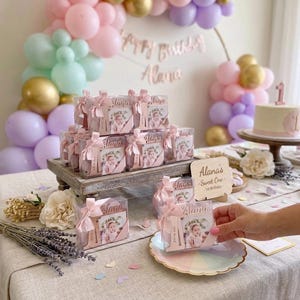 Bomboniere personalizzate con cornice portafoto e magnete color oro rosa per il primo compleanno.