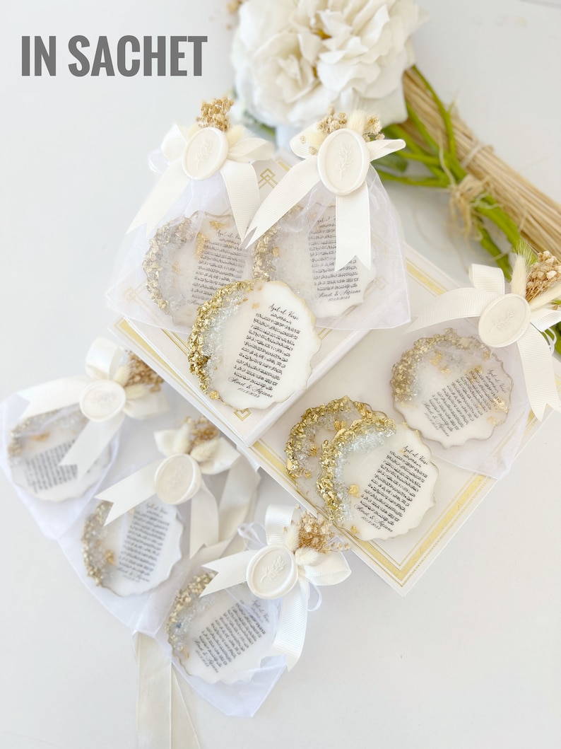 May include: White organza bags with gold glitter and white wax seals, filled with small white paper scrolls with gold lettering. The scrolls have Arabic text and the words "Special Love" written on them. The bags are tied with white ribbon and decorated with dried flowers.