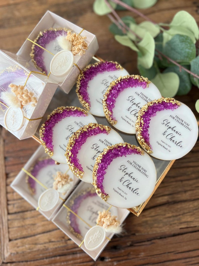 May include: Purple and gold wedding favor coasters with the text "Thank you for celebrating Stephanie & Charlie August 1st, 2023 Virginia Beach, VA"