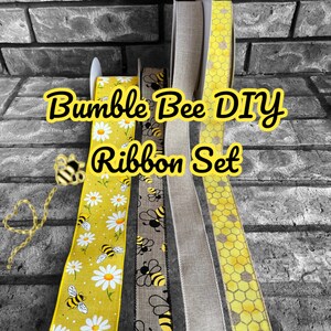 May include: A set of four yellow and black ribbon featuring a bumble bee and daisy design, a bumble bee design, a solid beige ribbon, and a yellow honeycomb design. The ribbons are labeled "Bumble Bee DIY Ribbon Set".