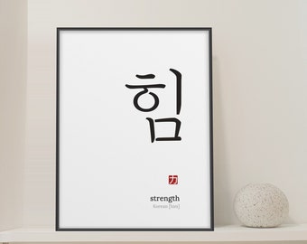 May include: A framed wall art print featuring the black Korean characters for strength, which are written as him, positioned above a small red square stamp, the word strength, and the text Korean [him] in a clean, minimalist black frame.