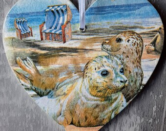 Seals on the the beach on a heart wall hanging.  Beach scene - Deckchairs on the beach