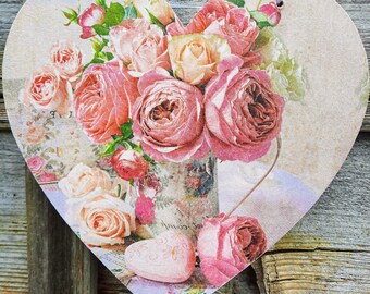 Heart wall hanging with pink flowers on wood.  Pink roses and peonies in different shades of pink on a heart plaque