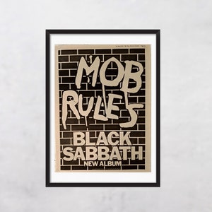 May include: Black and white poster with the text "MOB RULES" in large, bold, white letters against a black brick wall background. The text "BLACK SABBATH NEW ALBUM" is below the main text.