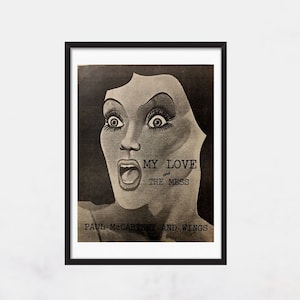 May include: Black and white poster with a woman's face, with a torn piece of paper over her face. The text on the poster reads "My Love and The Mess" and "Paul McCartney and Wings".