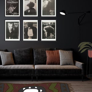 Puede incluir: Un sof&aacute; negro con tres almohadas, una almohada a cuadros blanco y negro, una almohada marr&oacute;n y una almohada blanca. El sof&aacute; est&aacute; frente a una pared negra con seis carteles enmarcados. Los carteles son de varios m&uacute;sicos, incluyendo  "Nervous Breakdown", "Eno", "Dylan", "Black Flag", "Walis", y "Davey  Peppers".