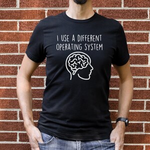 May include: A black t-shirt with white text that reads "I use a different operating system" and a white outline of a brain with a face.