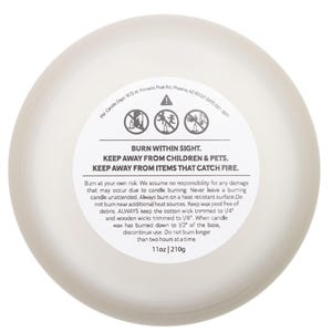 May include: A round, off-white candle with a white label. The label features safety warnings: "BURN WITHIN SIGHT," "KEEP AWAY FROM CHILDREN & PETS," and "KEEP AWAY FROM ITEMS THAT CATCH FIRE." The candle weighs 11oz.