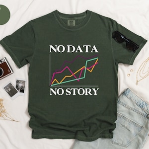Może przedstawiać: Zielony T-shirt z białym nadrukiem "NO DATA NO STORY" i kolorowym wykresem liniowym.