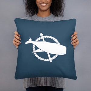 Peut inclure: Un coussin bleu avec un motif de baleine blanche et de boussole. La baleine est à l'intérieur d'un cercle de corde avec une aiguille de boussole et une flèche.