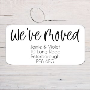 May include: White rectangular sticker with black text that reads "We've Moved" followed by the names Jamie & Violet, the address 10 Long Road, Peterborough, and the postcode PE8 6FC.