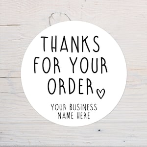 Peut inclure: Autocollant rond blanc avec du texte noir qui dit "Merci pour votre commande" avec un petit symbole de cœur. En dessous du texte se trouve "Votre nom d'entreprise ici."