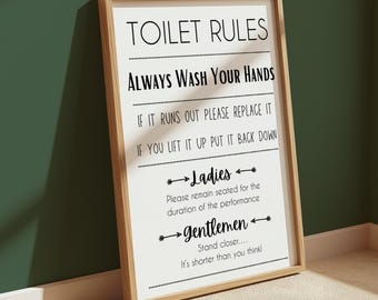 May include: A rectangular wall sign in a light wood frame featuring the black text TOILET RULES, Always Wash Your Hands, If it runs out please replace it, If you lift it up put it back down, Ladies please remain seated, and gentlemen stand closer.