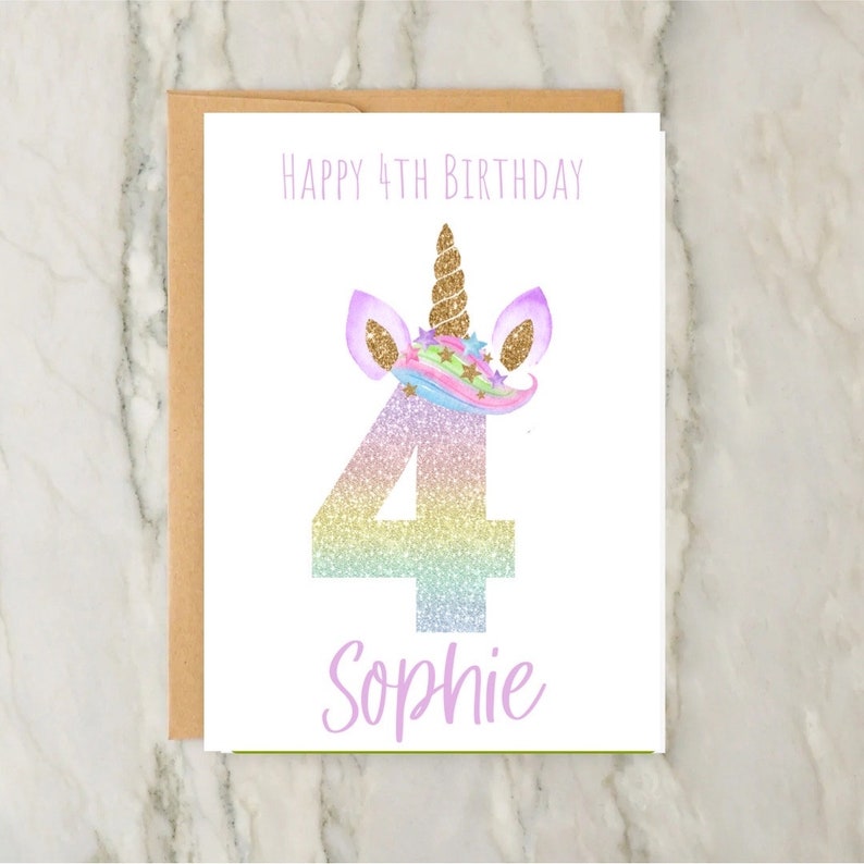 May include: A birthday card with a unicorn theme. The card features the text "Happy 4th Birthday" at the top, a large number "4" in a rainbow glitter design, and the name "Sophie" at the bottom. The unicorn has a gold horn and purple ears.