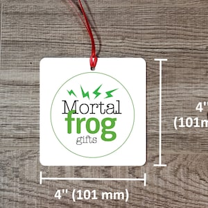 May include: White square gift tag with a green circle logo that says "Mortal frog gifts" with lightning bolts around the circle. The tag measures 4 inches by 4 inches.