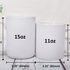 K&ouml;nnte beinhalten: Zwei wei&szlig;e Keramikbecher, einer mit 15oz und einer mit 11oz, mit Ma&szlig;en in Zoll und Millimetern. Die Becher stehen auf einer Holzoberfl&auml;che.