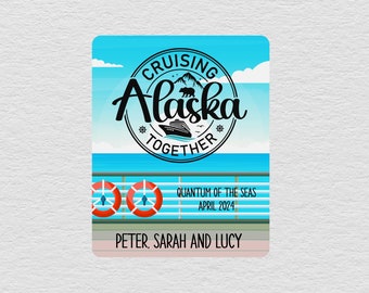 May include: A blue and white cruise ship themed card with the text "Cruising Alaska Together" in a black circle with a bear and mountain graphic. The text "Quantum of the Seas" and "April 2024" are below the circle. The text "Peter, Sarah and Lucy" is at the bottom of the card.