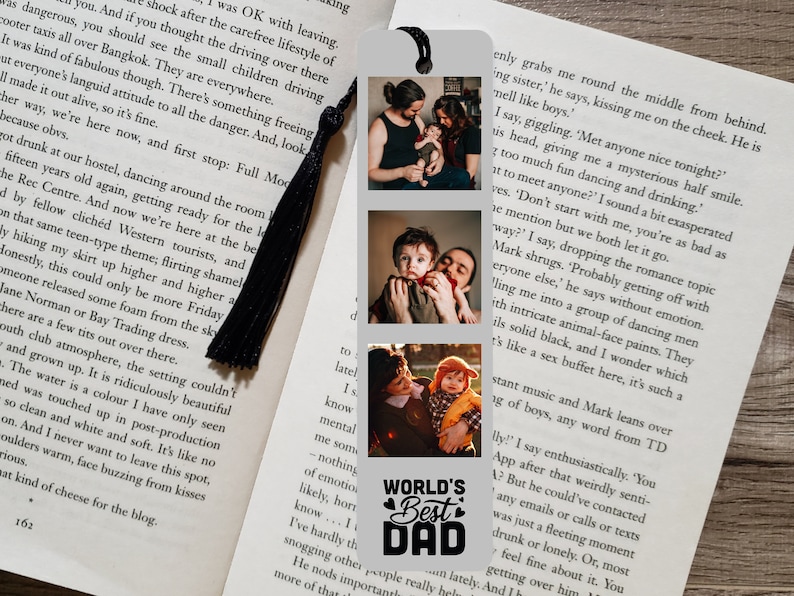 Puede incluir: Un marcap&aacute;ginas plateado con tres fotos de un padre y su hijo. Las fotos est&aacute;n dispuestas verticalmente. La foto de abajo incluye el texto "World's Best Dad" con corazones a cada lado de la palabra "Best".