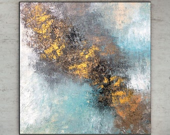 May include: Abstract painting with a blue, gray, and gold color scheme. The painting has a textured look and is framed in a black frame.