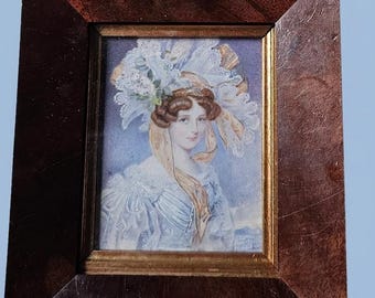 A portrait miniature of a perky lady. With an elaborate bonnet, Circa 1830s.